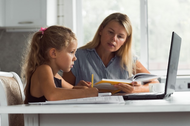 mère et fille utilisant un concept d'apprentissage en ligne pour ordinateur portable