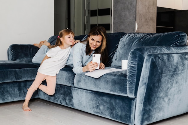 Photo mère et fille en utilisant le téléphone mobile ensemble