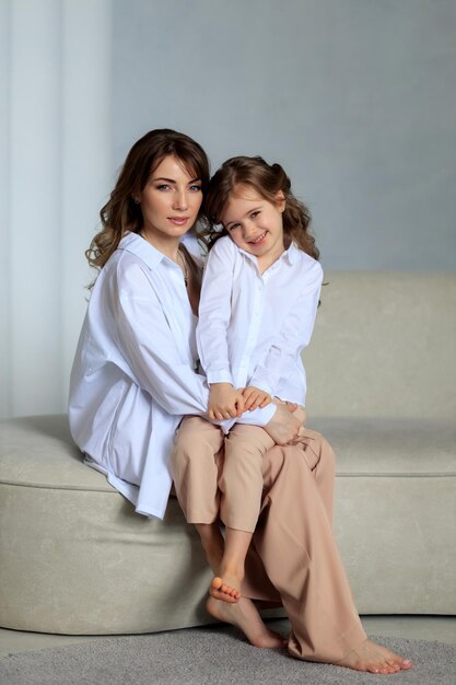 Mère et fille en vêtements classiques à la maison dans un bel intérieur