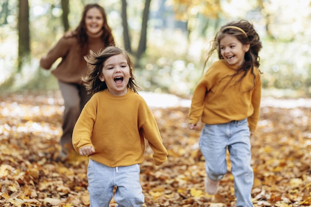 Mère avec filles s'amusant dans un parc automnal