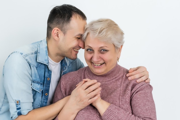 Mère et fils adulte ensemble, fils donnant un baiser à sa mère.