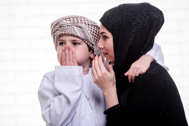 Mère et fils arabe posant à l'intérieur.