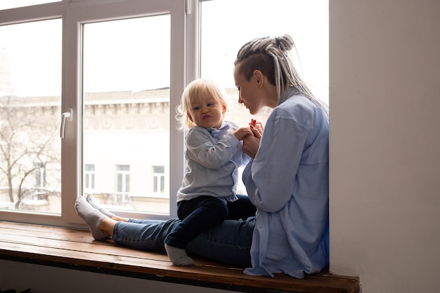 Mère et fils assis sur le rebord près de la fenêtre