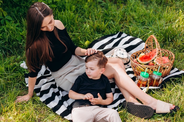 Mère et fils ayant un pique-nique dans le parc.