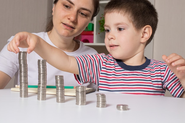 Mère et fils construisent des tours de pièces de monnaie.