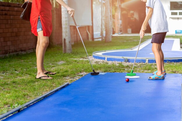 Mère et fils garçon jouant au mini golf