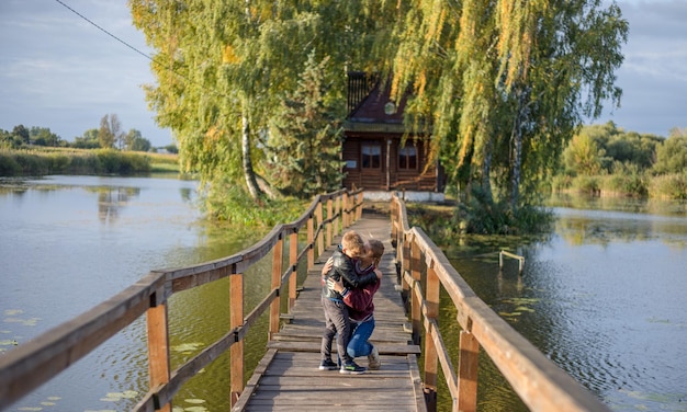 Mère et fils heureux saluent fièrement et s'embrassent ensemble maman et adorable petit enfant jouant ensemble en plein air