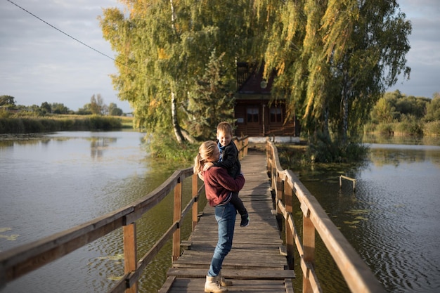 Mère et fils heureux saluent fièrement et s'embrassent ensemble maman et adorable petit enfant jouant ensemble en plein air