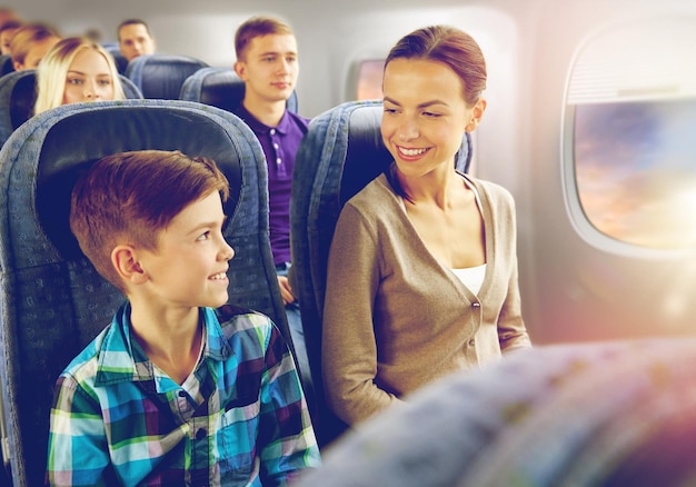 Photo mère et fils heureux voyageant en avion