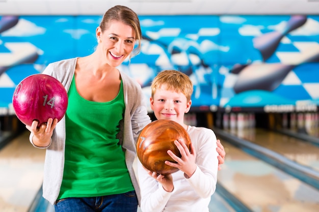 Mère Et Fils Jouant Ensemble Au Centre De Bowling