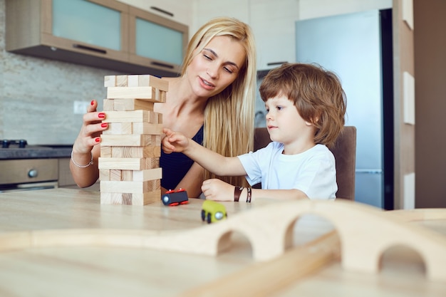 Mère et fils jouent à la table à l'intérieur.
