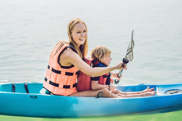 Mère et fils kayak à l'océan tropical