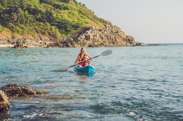 Mère et fils kayak à l'océan tropical