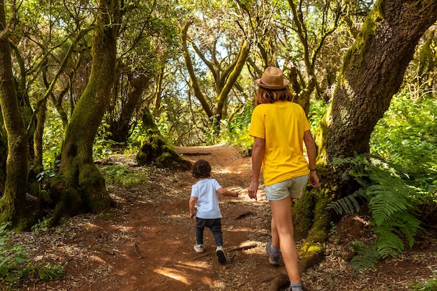 Mère et fils marchant dans La Llania sur El Hierro Îles Canaries Sur un chemin de laurier d'El Hierro dans un paysage verdoyant