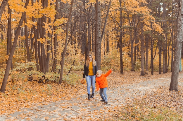 Mère et fils marchant dans le parc d'automne et profitant de la belle saison nature d'automne célibataire