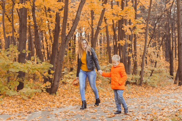 Mère et fils marchant dans le parc d'automne et profitant de la belle saison nature d'automne célibataire