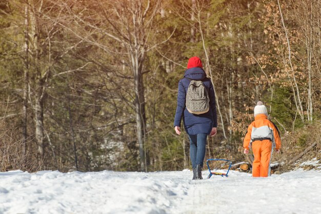 Mère avec fils marchant le long de la neige