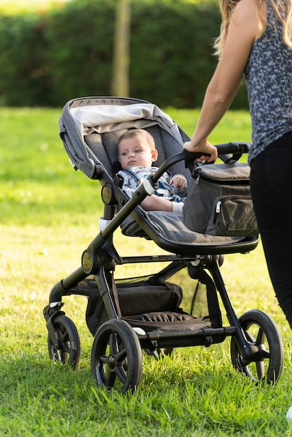 Mère et fils marchant avec la poussette dans le parc