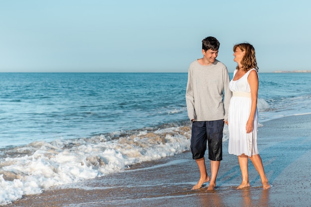 Mère et fils marchant et profitant de la plage