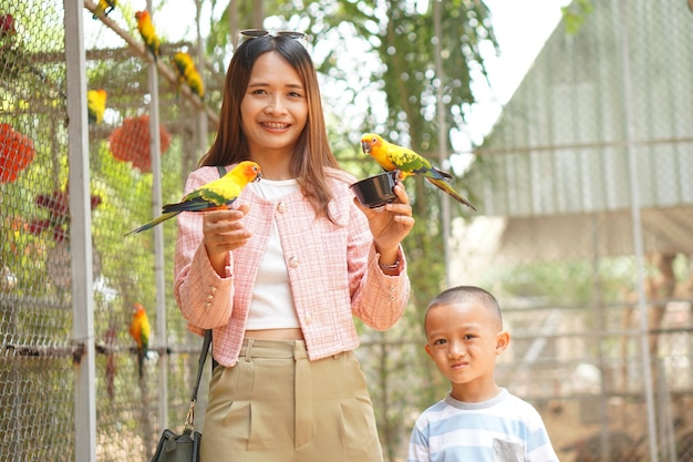 Mère et fils nourrissant des oiseaux en vacances