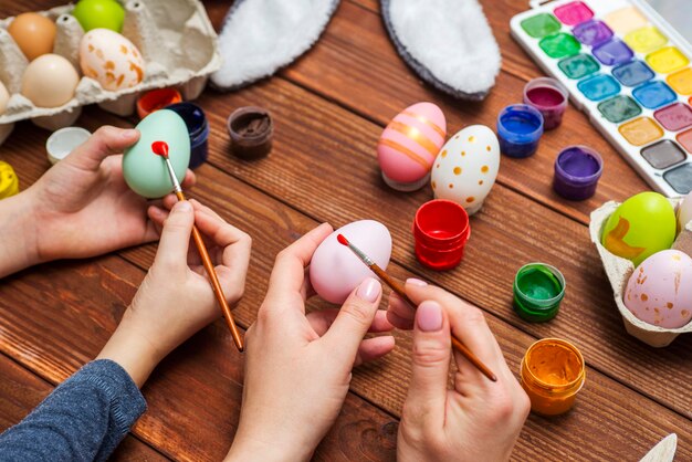 Photo mère et fils peignent des oeufs de pâques