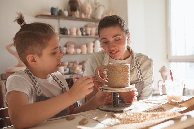 Photo mère et fils s'amusant à faire de la poterie ensemble