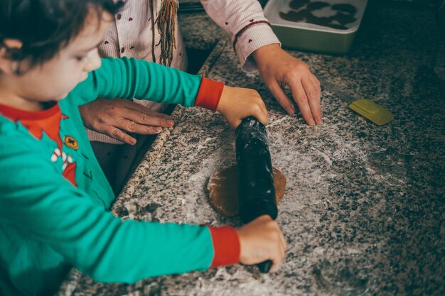 Mère et fils se renforcent en riant et en s'aimant pendant qu'ils préparent le pain d'épice de Noël.