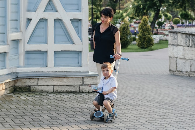 Mère avec fils soutien scooters en été