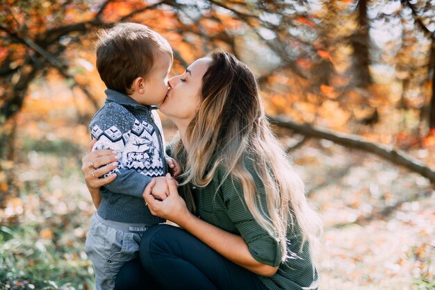 Mère avec fils trois ans en automne la forêt, étreinte et tendresse