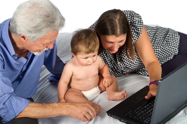 Mère et grand-père avec bébé jouer avec pc