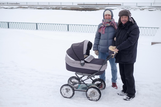 Mère et grand-père marchant avec un enfant dans une poussette