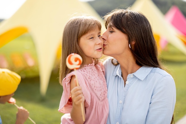 Une mère heureuse avec sa petite fille visite un parc d'attractions