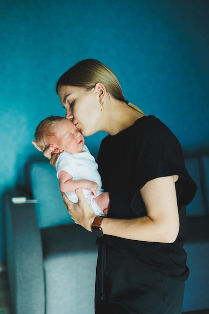 Une mère heureuse tient un nouveau-né dans ses bras Une jeune mère étreint un nouveau-né Mère et enfant à la maison