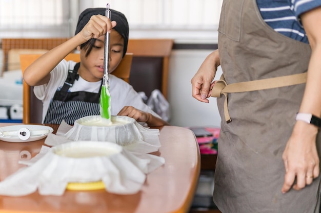 Mère avec jeune fils faisant cuire le gâteau dans la cuisine