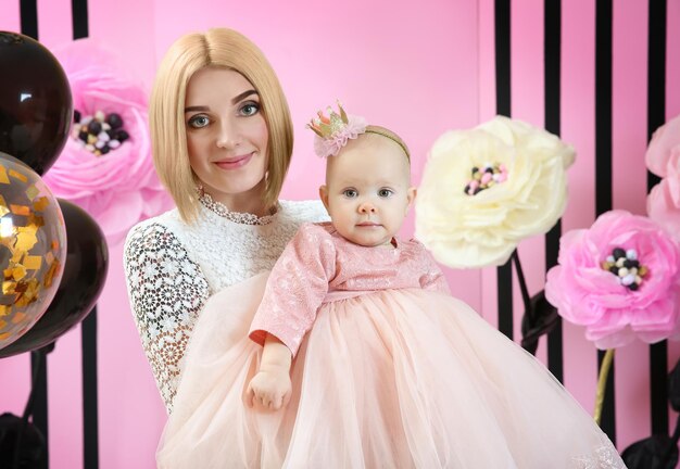 Mère avec une jolie petite fille dans la chambre décorée pour la fête d'anniversaire