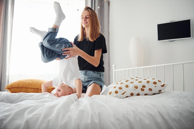 Mère jouant et s'amusant avec son fils dans la chambre pendant la journée.