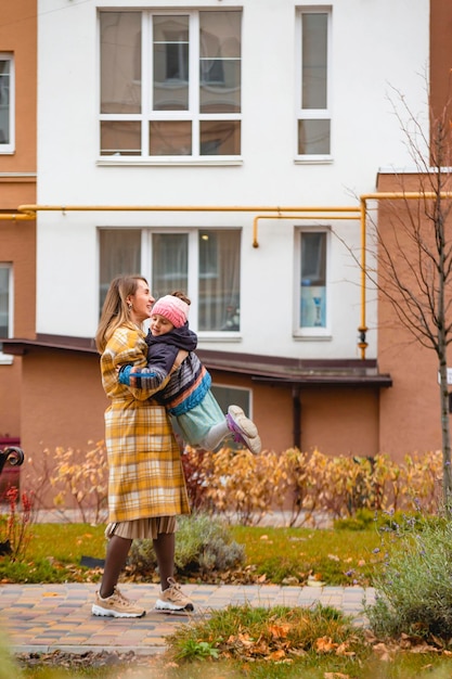 Mère jouant avec sa fille sur les couleurs d'automne de la rue d'automne