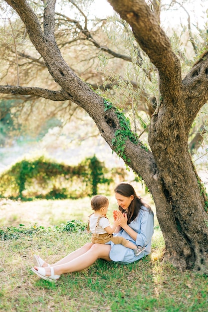 Mère jouant avec sa fille près de l'arbre