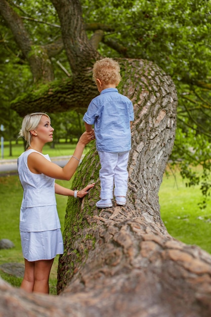 Mère jouant avec son enfant sur un arbre dans le parc.