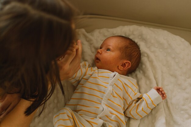 Mère jouant avec son nouveau-né à la maison