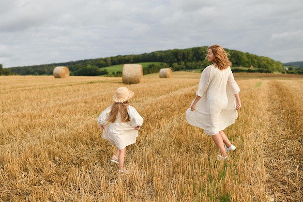 Mère joue avec sa fille dans un champ de blé