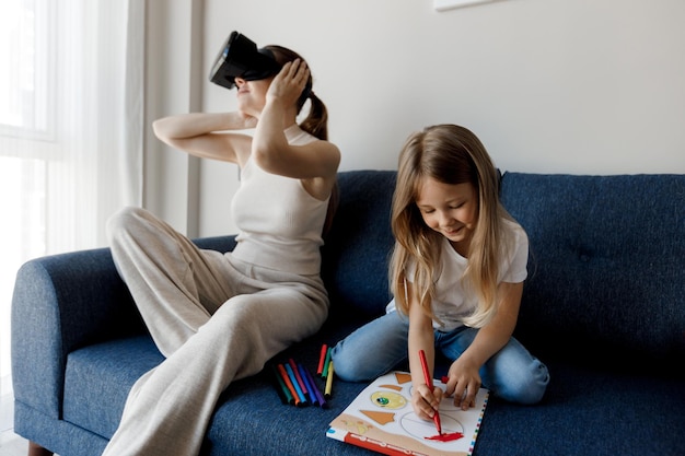 mère à lunettes VR pendant que sa fille joue et étudie