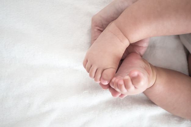 Mère main tenir bébé pied