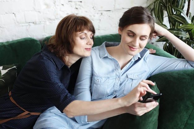 Mère mature et sa fille faisant un selfie à l'aide d'un téléphone intelligent