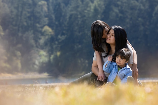 Mère mexicaine avec sa fille et son fils s'embrassant à l'extérieur