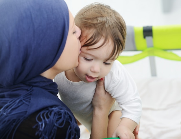 Mère musulmane arabe jouant et prenant soin de son bébé
