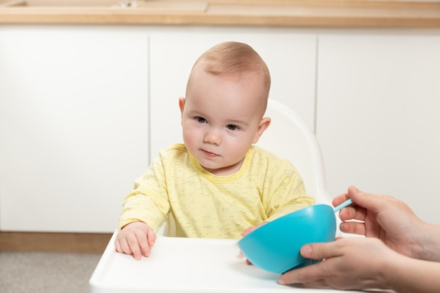 Mère nourrir bébé assis sur une chaise