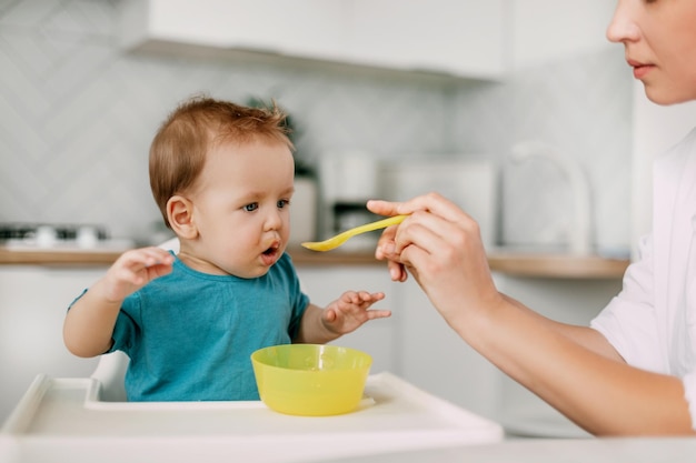 Mère nourrissant son garçon à la maison