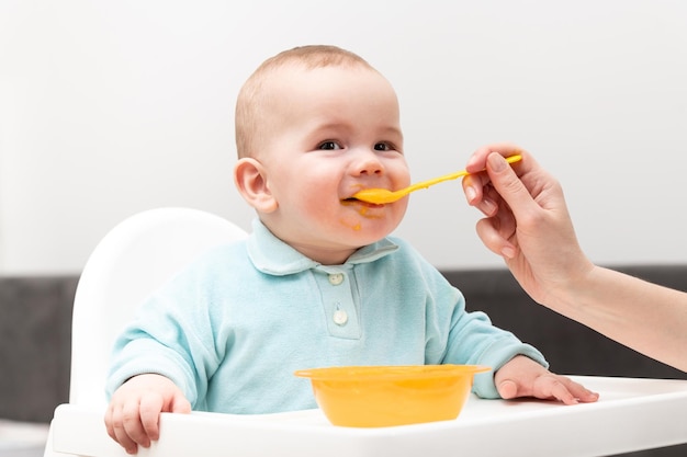 Mère nourrissant son petit bébé à la maison