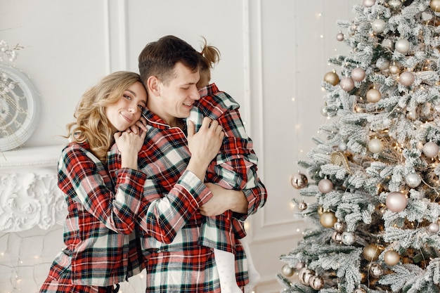 Mère père et fille étreignant près de l'arbre de Noël